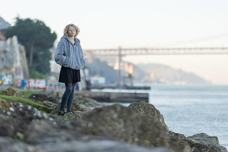 wanita muda berdiri di tepi sungai tampak bijaksana - hoodie dan rok potret stok, foto, &amp; gambar bebas royalti