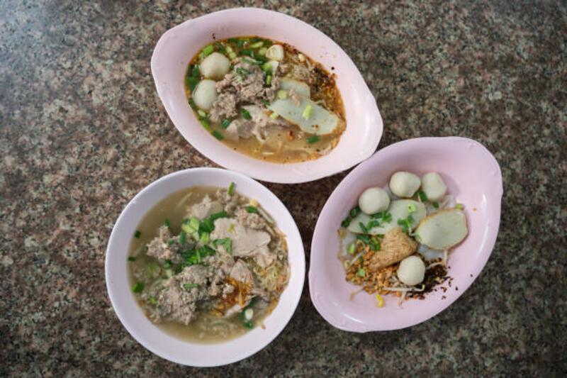 Thai local noodle dishes featuring clear soup noodles and dry noodles served in bowls. Thai local noodle dishes featuring clear soup noodles and dry noodles served in bowls. Popular thai local food. fish ball stock pictures, royalty-free photos &amp; images