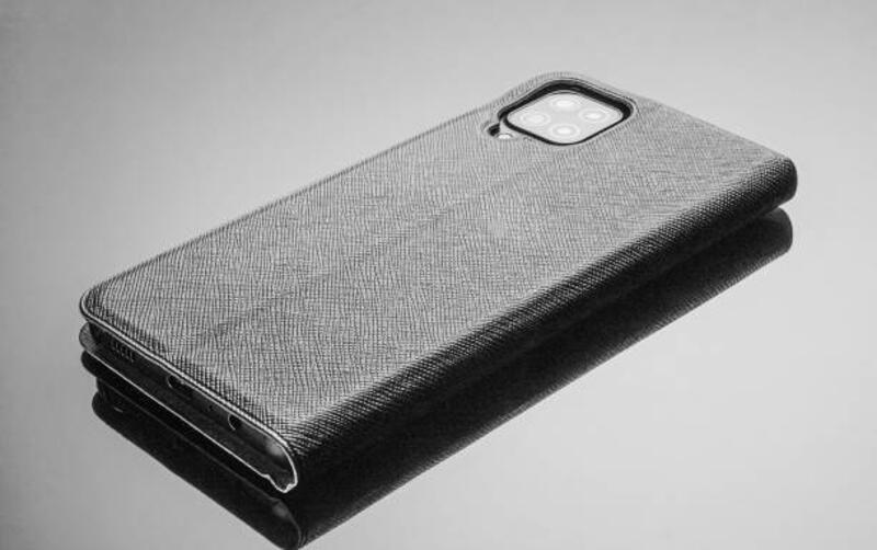 smartphone-dalam-casing-kulit-hitam-terletak-pada-latar-belakang-hitam.jpg (612×384)