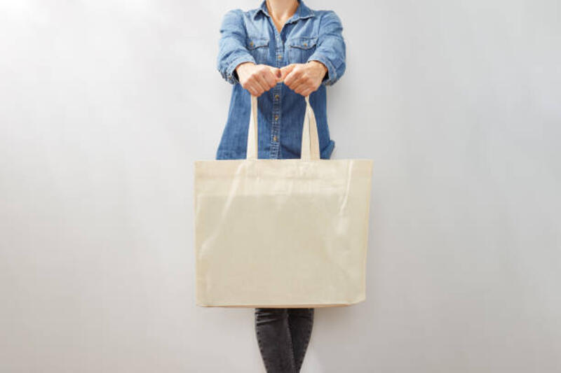 wanita muda yang tidak dapat dikenali dengan kemeja denim dengan tas jinjing ramah lingkungan kanvas kosong - tote bag canvas potret stok, foto, &amp; gambar bebas royalti