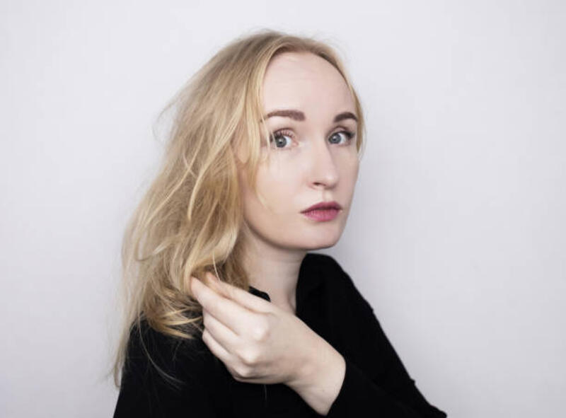 blonde woman unhappy with her hair condition and trying to brush it. bad hairstyle, tangled curly hair without using conditioner. - catokan rambut problem potret stok, foto, &amp; gambar bebas royalti