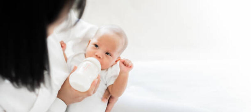 Mother feeding asian baby with bottle of milk, banner copy space Mother feeding asian baby with bottle of milk, banner copy space BABY MILK stock pictures, royalty-free photos &amp; images