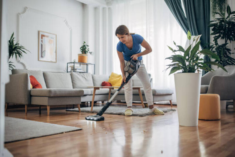 Woman vacuuming the living room with cordless vacuum cleaner Woman vacuuming the living room with cordless vacuum cleaner cordless vacuum cleaner stock pictures, royalty-free photos &amp; images