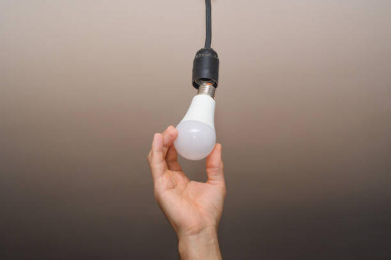 Di tangan pria itu ada bola lampu listrik. LED listrik.