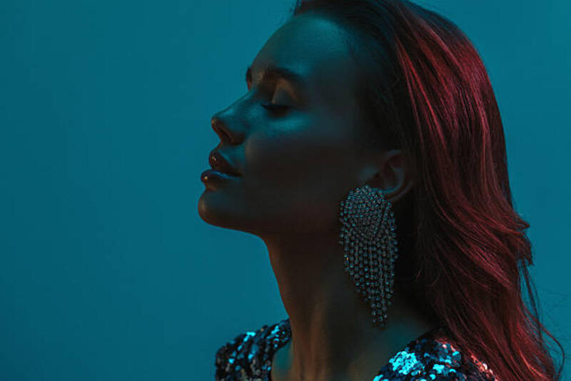 wanita elegan dalam pencahayaan dramatis mengenakan anting-anting pernyataan - wanita kulit gelap  potret stok, foto, &amp; gambar bebas royalti