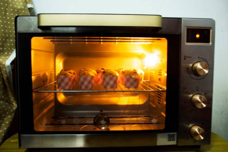 koki roti orang thailand memasak kue panggang pisang cangkir kue topping chocolate chip panggang dalam oven listrik - kue dalam oven listrik potret stok, foto, &amp; gambar bebas royalti