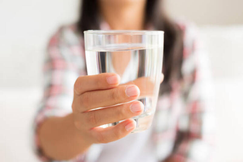 bahagia wanita muda cantik memegang gelas air minum di tangannya. konsep perawatan kesehatan. - minum air putih potret stok, foto, & gambar bebas royalti