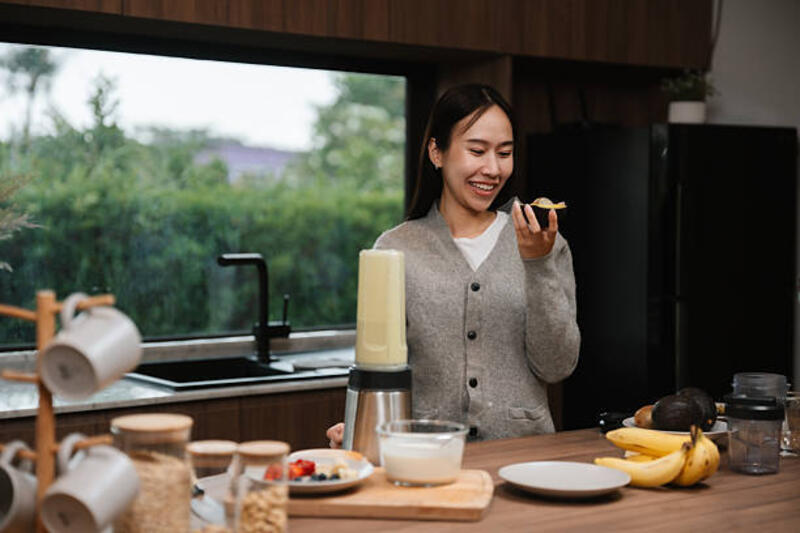 woman using smartphone to check nutrition of homemade green smoothie - portable juicer potret stok, foto, &amp; gambar bebas royalti