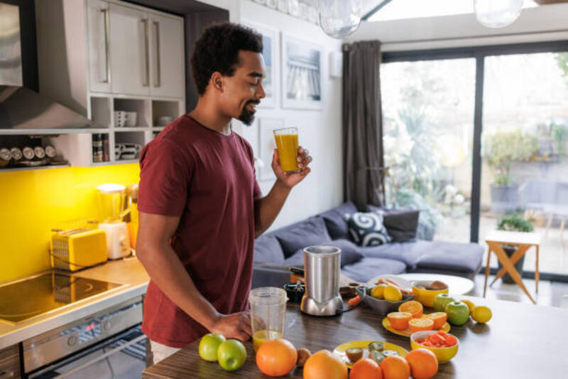 diet sehat dan detoksifikasi - pria muda minum smoothie segar di rumah - simple smoothie potret stok, foto, &amp; gambar bebas royalti