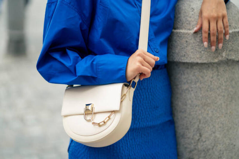 wanita dengan kemeja biru dan tas bahu putih berdiri santai - shoulder bag potret stok, foto, &amp; gambar bebas royalti