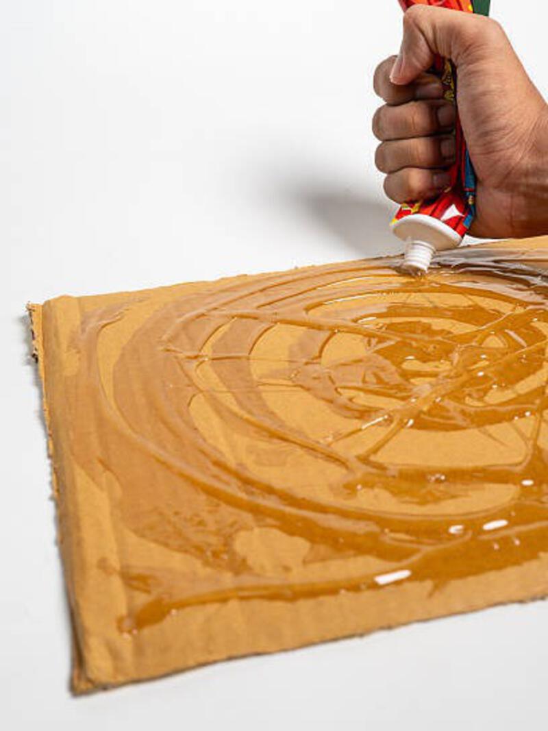 Close up of hands applying rat glue to cardboard Close up of hands applying rat glue to cardboard, ready for pest control and rodent trapping. mouse glue stock pictures, royalty-free photos &amp; images