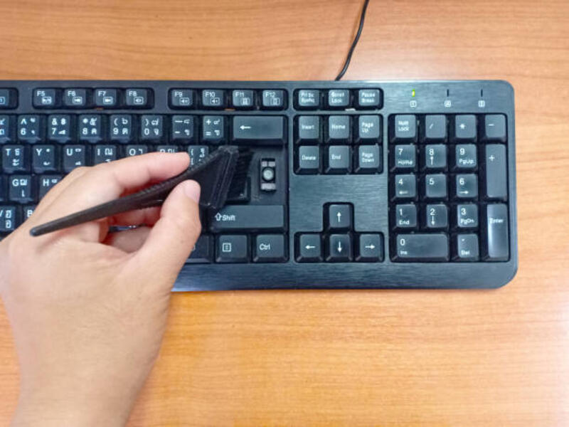 tangan wanita memegang sikat hitam untuk membersihkan keyboard hitam dengan latar belakang kayu. tombol enter rusak dari keyboard. - membersihkan keyboard terbalik potret stok, foto, &amp; gambar bebas royalti
