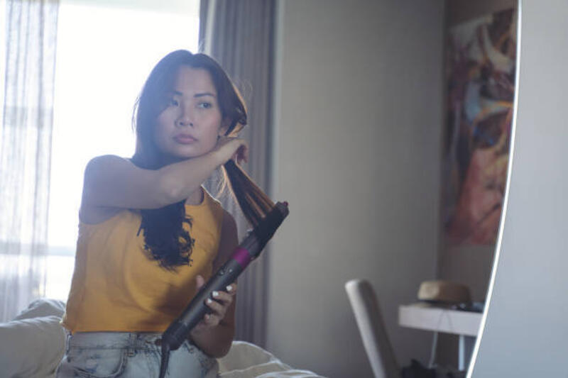 wanita menggunakan pelurus rambut - catokan rambut curly potret stok, foto, &amp; gambar bebas royalti