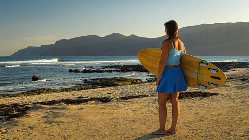 wanita muda yang sporty memeriksa ombak indah yang pecah dalam angin lepas pantai - skort wanita potret stok, foto, &amp; gambar bebas royalti