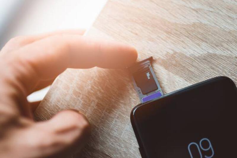 Man memasukkan kartu memori dan kartu sim