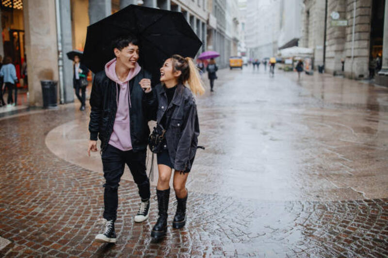 pasangan jatuh cinta berjalan menyusuri highstreet memegang payung - fashion musim hujan pria potret stok, foto, &amp; gambar bebas royalti