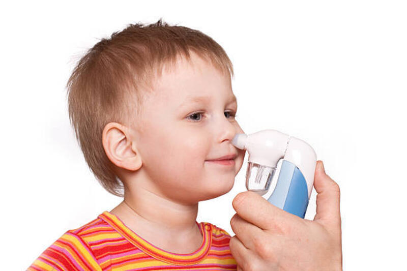 Using nasal aspirator Little boy using nasal aspirator isolated on white background nasal aspirator stock pictures, royalty-free photos &amp; images