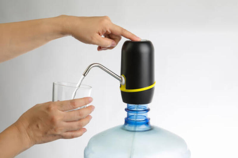 wanita tangan tekan filter pemurnian air untuk air minum - electric pump galoon potret stok, foto, &amp; gambar bebas royalti