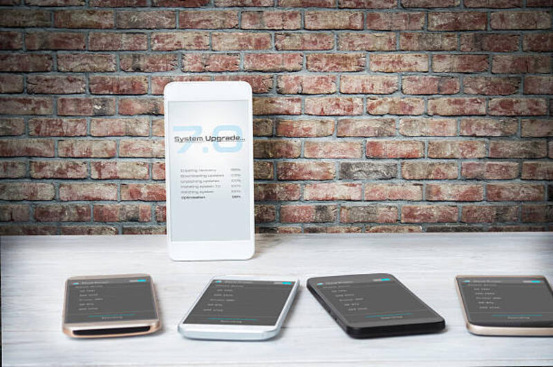 smartphone kelas atas selama instalasi perangkat lunak versi baru - updating phone system potret stok, foto, &amp; gambar bebas royalti