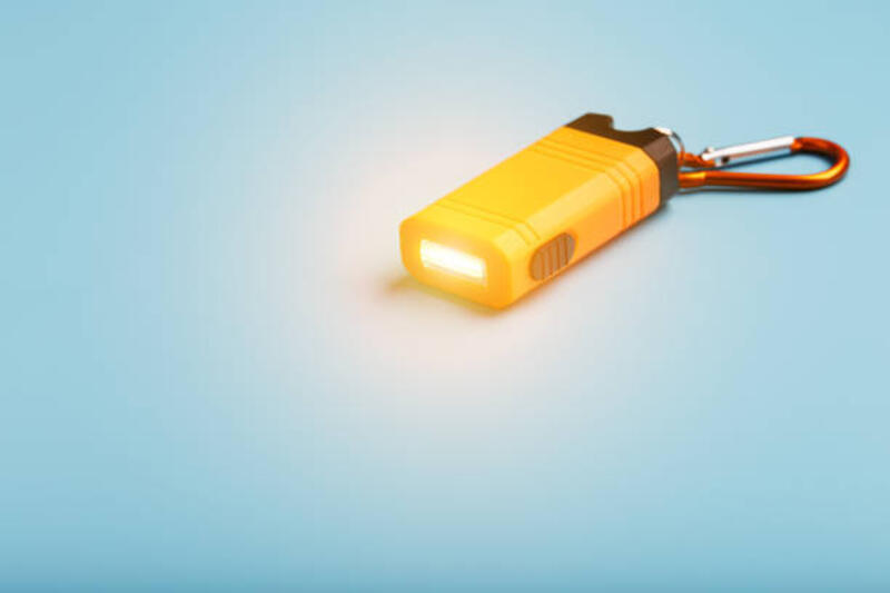 orange memimpin senter dengan carabiner pada latar belakang biru. lampu led dalam penerbangan. - senter kunci kecil potret stok, foto, & gambar bebas royalti