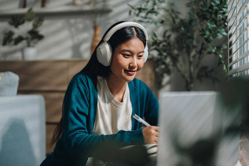 woman enjoying her online class, attentively taking notes as she stays engaged and focused - online student potret stok, foto, & gambar bebas royalti