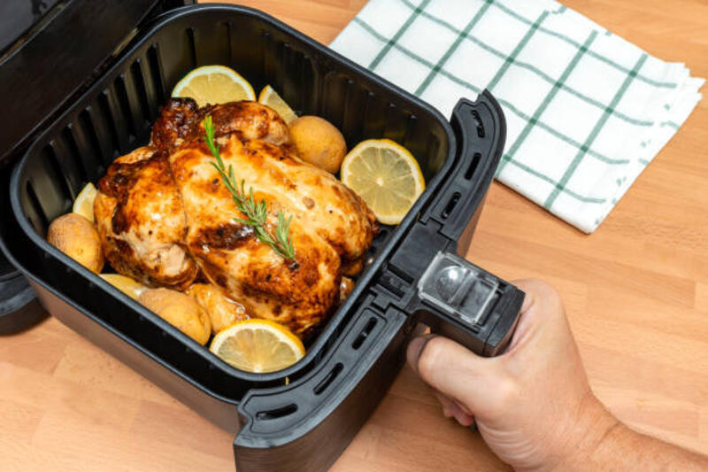 memasak ayam panggang utuh dengan hiasan di air fryer di dapur. tampilan atas. - airfryer potret stok, foto, & gambar bebas royalti