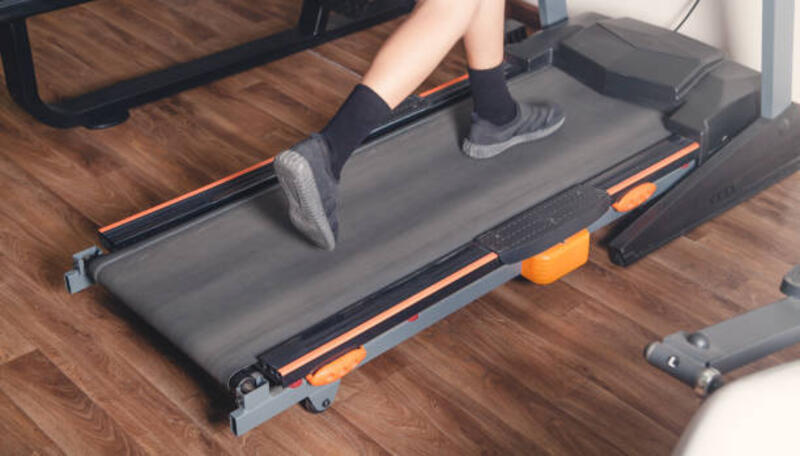 Anak laki-laki berjalan di treadmill di gym.