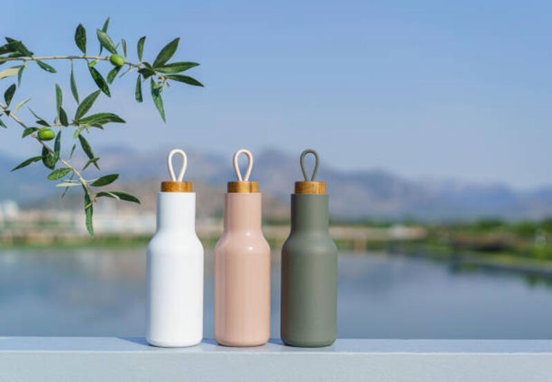botol air logam modern dengan semak-semak pohon zaitun, permukaan air di latar belakang - aesthetic water bottle potret stok, foto, & gambar bebas royalti