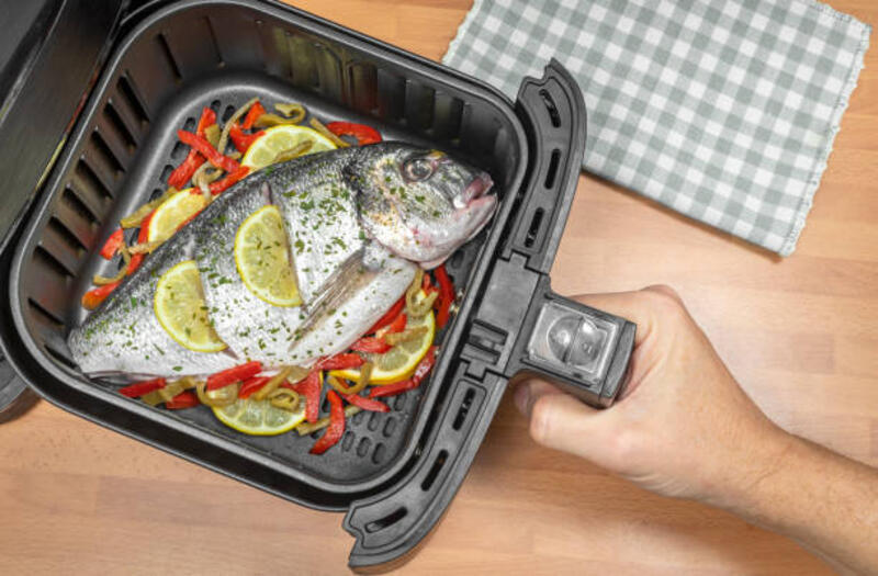 memasak ikan sea bream utuh dengan hiasan di air fryer. - penggoreng udara potret stok, foto, &amp; gambar bebas royalti