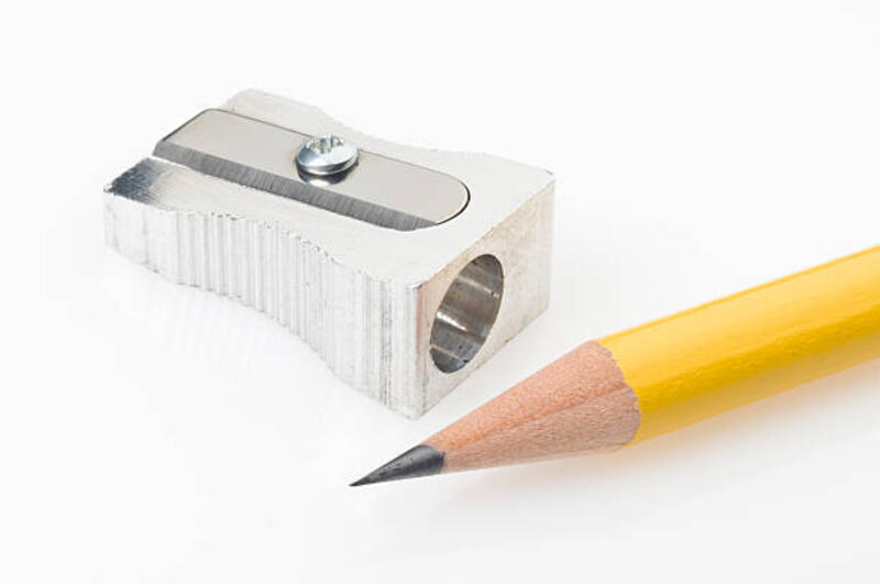 Yellow pencil tip and sharpener on white background Close up of a yellow pencil tip and sharpener on white background. The pencil is on foreground with a sharp tip and the shiny metal pencil sharpener is on background. pencil sharperner stock pictures, royalty-free photos &amp; images