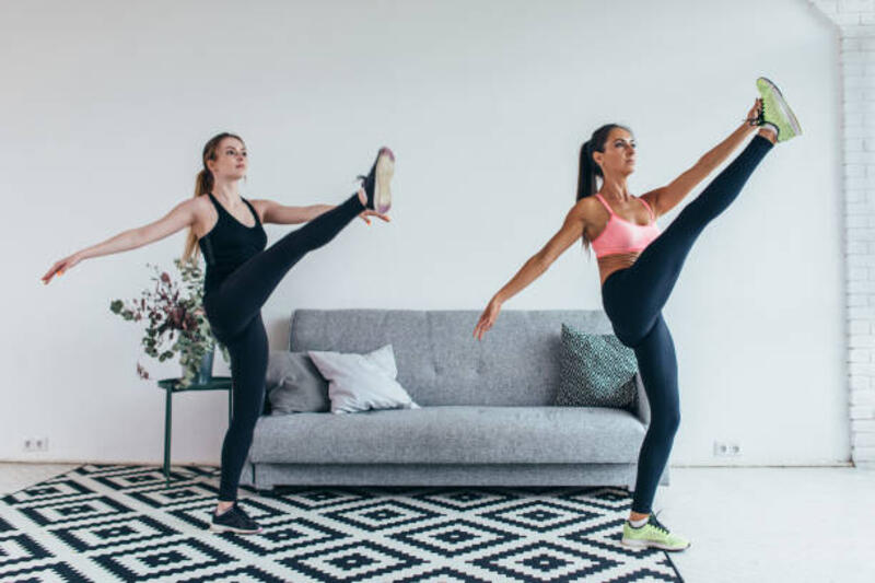 fit wanita peregangan kaki pemanasan latihan di rumah - leg swings exercise potret stok, foto, &amp; gambar bebas royalti