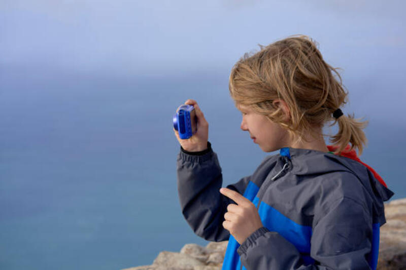 a-young-child-with-blond-hair-using-a-compact-digital-camera-to-take-pictures-by-the-sea.jpg (612×408)