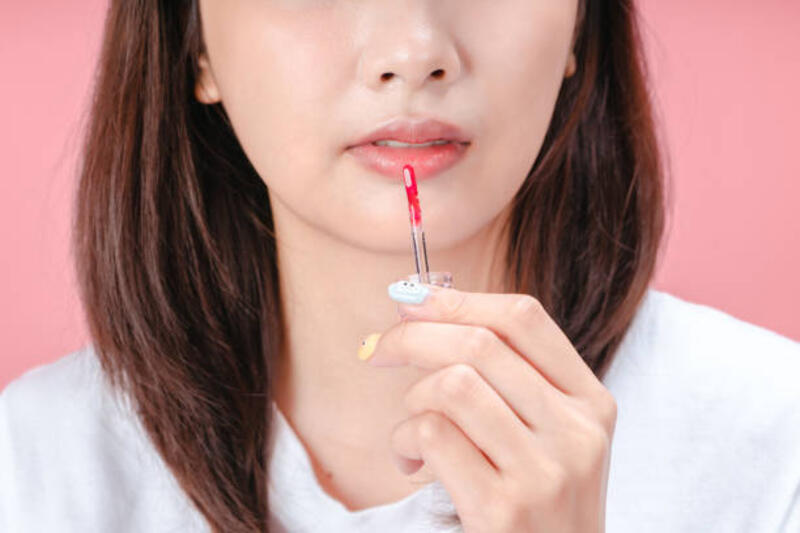 tampilan-yang-dipotong-dari-wanita-muda-yang-mengoleskan-lip-gloss-saat-melakukan-riasan-yang.jpg (612×408)